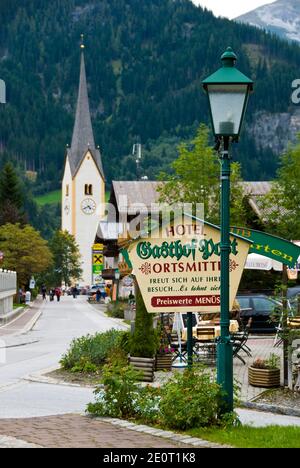 The village church and sign for a guest house in Krimml, Austria. Stock Photo