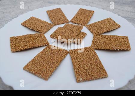 Til sakri or Tilgul an Indian traditional popular sweet made out of Sesame seeds and jaggery. Famous Sankranti festival dessert arranged on white plat Stock Photo