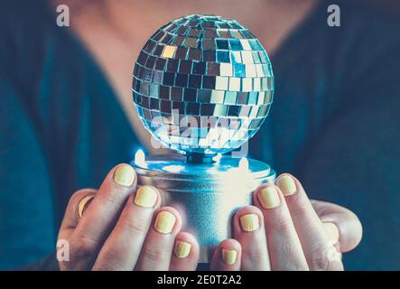 A woman holding a shiny disco ball Stock Photo