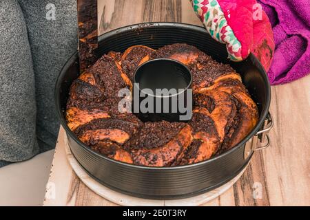 Taking out the backed chocolate cake from the round backing pan Stock Photo