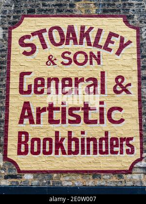 Painted Wall Advert Cambridge - controversial restoration of a Ghost Sign in Green Street Cambridge for Stoakley & Son General & Artistic Bookbinders. Stock Photo