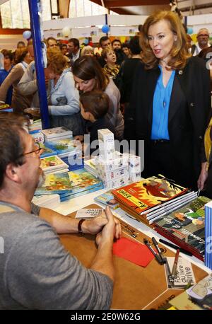 Valerie Trierweiler presente son livre en compagnie du photographe Stephane Ruet durant le 31° Salon du Livre de Brive en Correze le 10 Novembre 2012. Valerie Trierweiler a profité de la ville en se promenant et en visitant le marche. Ils posent sur leur stand avec Erik Orsenna president du Salon litteraire. Photo by Patrick Bernard/ABACAPRESS.COM Stock Photo