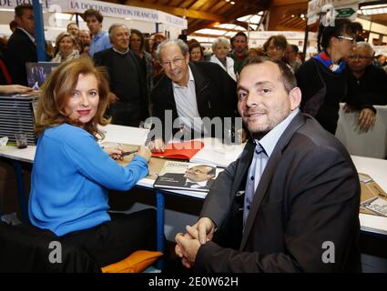 Valerie Trierweiler presente son livre en compagnie du photographe Stephane Ruet durant le 31° Salon du Livre de Brive en Correze le 10 Novembre 2012. Valerie Trierweiler a profité de la ville en se promenant et en visitant le marche. Ils posent sur leur stand avec Erik Orsenna president du Salon litteraire. Photo by Patrick Bernard/ABACAPRESS.COM Stock Photo