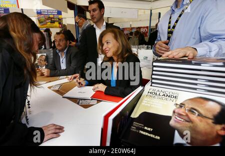 Valerie Trierweiler presente son livre en compagnie du photographe Stephane Ruet durant le 31° Salon du Livre de Brive en Correze le 10 Novembre 2012. Valerie Trierweiler a profité de la ville en se promenant et en visitant le marche. Ils posent sur leur stand avec Erik Orsenna president du Salon litteraire. Photo by Patrick Bernard/ABACAPRESS.COM Stock Photo