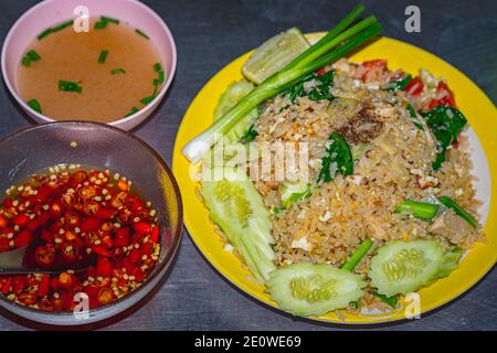 Thai fried rice with chicken (khao pad gai) on plastic plate for 1.2 US dollar at street food restaurant in Thailand. Stock Photo