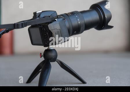 Digital Camera Stands On A Rotating Mini Tripod In The Studio Stock Photo