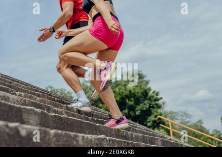 Close up and low below angle view photo of athletes legs running up concrete stairs Stock Photo