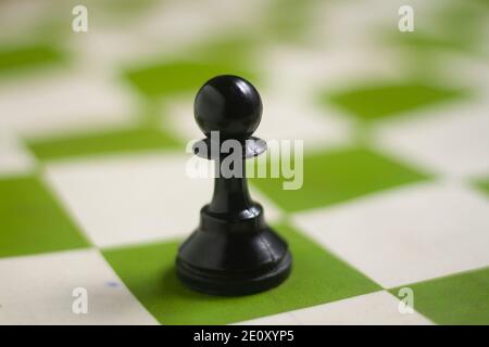 one side light on black pawn chess piece.close up