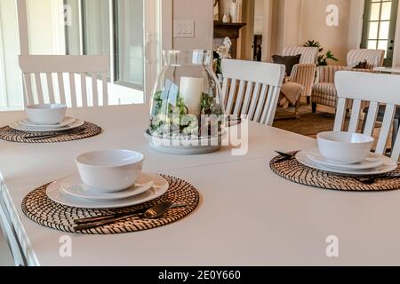 Tableware on dining table set for four persons with living area in background Stock Photo