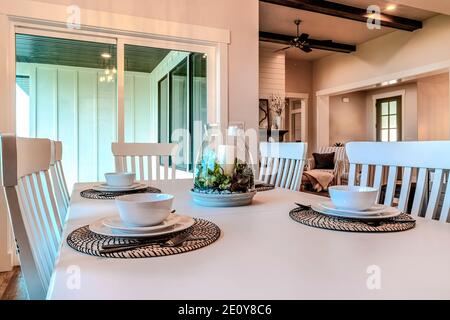 Dinner table set for four persons with tableware around a candle centerpiece Stock Photo