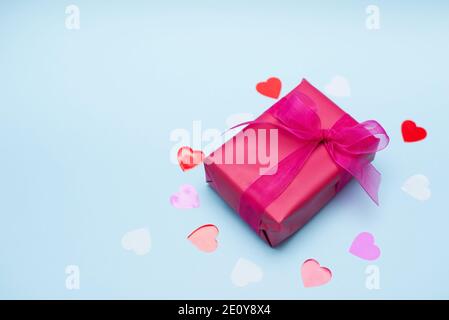 Valentine day background with red gift box with hearts on pastel blue background. Stock Photo