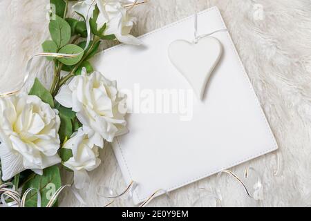 white book with bouquet of roses and white heart, concept of love Stock Photo