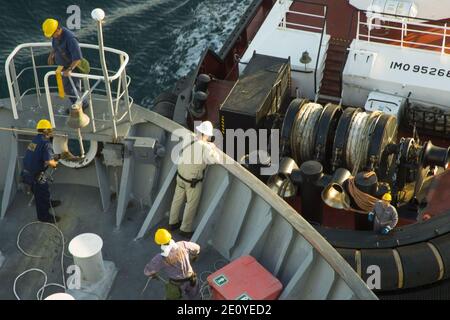 Line handlers aboard the roll-on-roll-off and container ship MV Cape Ray (T-AKR 9679) work with an Italian tugboat to moor the ship upon arriving at the Medcenter Container Terminal in Gioia Tauro, Italy 140701 Stock Photo