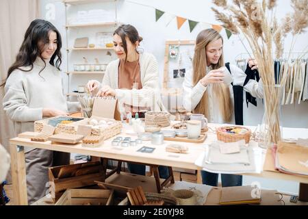Curious young women in ecological shop choose between various cosmetic products Stock Photo