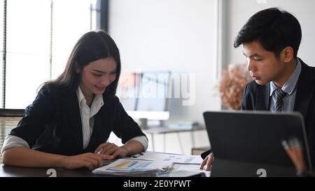 Two business people analysts and discussing online data while sitting in modern co working. Stock Photo