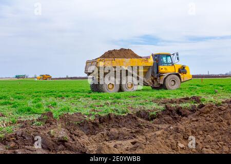 Dump truck is in transport on building site, passing over. Stock Photo