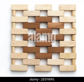 Wall made of small wooden bricks.  Brown and natural wooden blocks resembling wall of bricks on white background. Texture. Background. Stock Photo