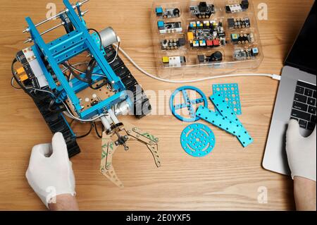 Kid working with robot in classroom close up view on wooden table Stock Photo