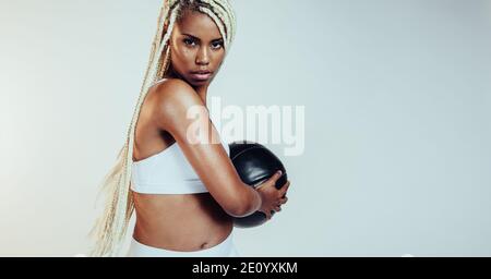 African american fitness woman working out using medicine ball. Fit woman doing twists holding a medicine ball. Stock Photo