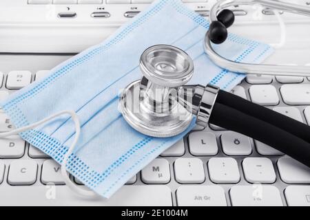 Face mask and stethoscope with PC keyboard Stock Photo