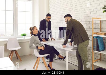 Happy young business people meeting in office and discussing interesting group project Stock Photo