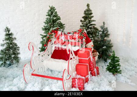 christmas decor sleigh and red gift boxes with green christmas trees on snow, holiday decoration Stock Photo