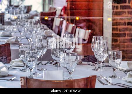 Restaurant interior with wine glasses and tableware and utensils on tables Stock Photo