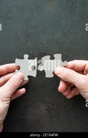 Two puzzle pieces in your hands Stock Photo