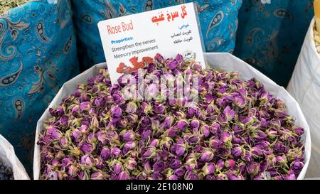 Pile of rose buds sold in a traditional Iranian market. Persian writing translates for rose buds Stock Photo