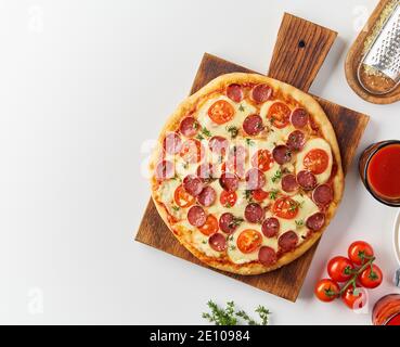 Top view hot homemade Italian pepperoni pizza with salami, mozzarella on white table Stock Photo
