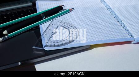 Stationery and squared notebook on laptop keyboard. Stock Photo