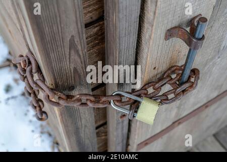 Close up view of rusty iron metal chain with gold plated combination padlock Stock Photo