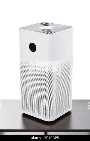 Air purifier with filter for cleaning fine dust PM2.5 odors and smoke isolated on white background with clipping path, standing on a dark table. Stock Photo