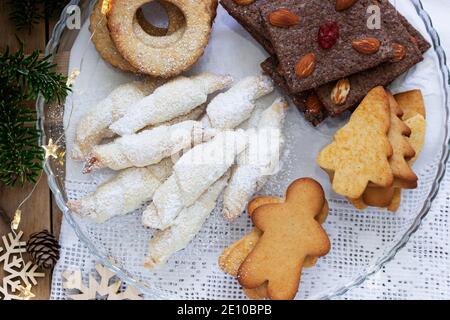 Assorted cookies, fir branches and a garland on a light background. Stock Photo