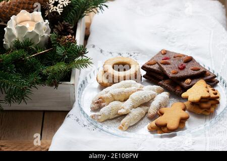 Assorted cookies, fir branches and a garland on a light background. Stock Photo