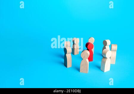 Red figurine of a man surrounded by people. Leader and significant person, important. Uniting around a team of people. Cooperation and teamwork. Attra Stock Photo