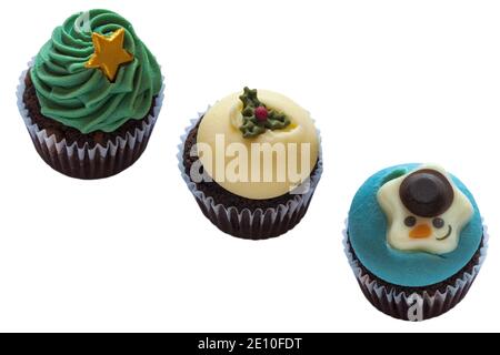 Christmas tree, snowman & Christmas pudding cupcakes cup cakes in a row, in a line, M&S mini festive cupcakes isolated on white background Stock Photo