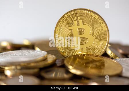A golden bitcoin standing among many blurred coins. Bitcoin is a cryptocurrency, a decentralized digital currency without a central bank Stock Photo