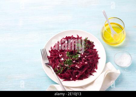Healthy detox raw beetroot salad with red onion, garlic, herbs and spices on a blue background. diet food. top view, free space Stock Photo