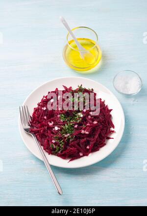 Healthy detox raw beetroot salad with red onion, garlic, herbs and spices on a blue background. diet food. top view Stock Photo