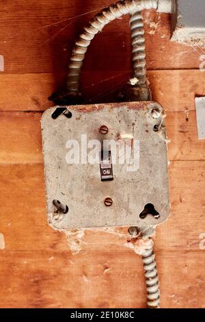 Electrical Switch in in On Mode, Set in Metal Junction Box on Wooden Surface with BX Cable Stock Photo