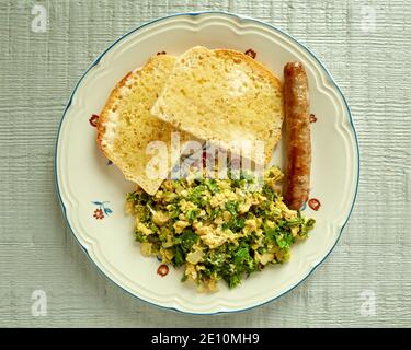 Topview of Kale and Eggs Scramble with Toast and Sausage on a Plate Stock Photo
