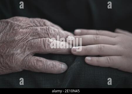 nephew touching grandfather's hand. Concept love and care of family members Stock Photo