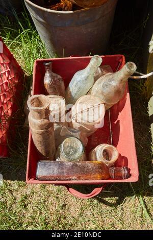 Plastic Crate of Old, Dusty Glass Bottles with Open Mouths Stock Photo