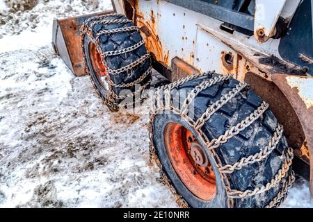 Old and rusty bulldozer with heavy duty black wheels wrapped in metal chains Stock Photo