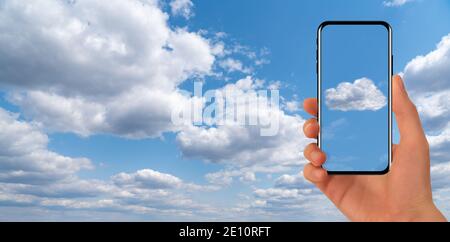 Hands with smartphone on a background of blue sky. Cloud service idea Stock Photo
