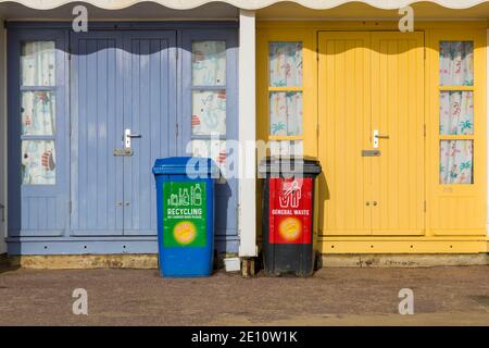 Recycling and general waste wheelie bins outside beach huts at Bournemouth, Dorset UK in December Stock Photo