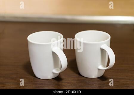 Brewing coffee in the brewing unit. Two white mugs and pouring hot, steaming coffee. Stock Photo