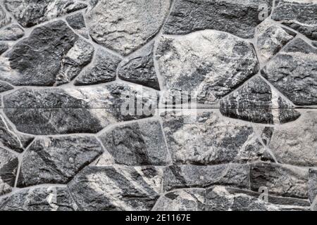 Artificial stone backdrop is similar to natural. It can look like onyx or marble or granite or any other black stone. Close-up. Stock Photo