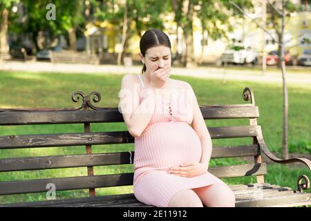 pregnant woman suffering from toxicosis in the park. Stock Photo